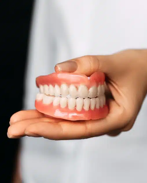 Full denture held in a hand